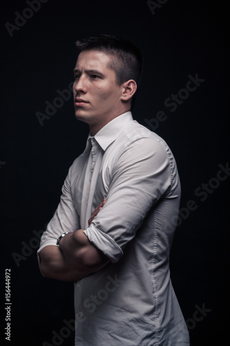 Фотография one young man, side view, looking tense, black background
