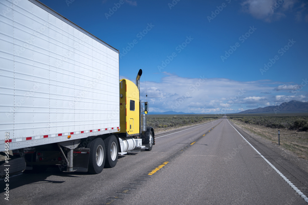 Yellow American semi-truck reefer transit Nevada road