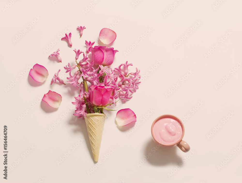 Flowers in a waffle cone with yogurt on white background