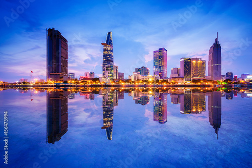 Cityscape in reflection of Ho Chi Minh city at beautiful twilight  viewed over Saigon river. Hochiminh city is the largest city in Vietnam with population around 10 million people