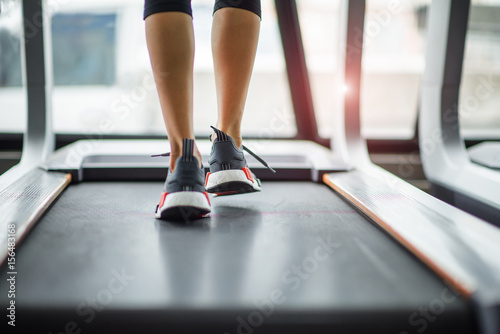 step of woman legs jogging on the treadmill in gymnasium