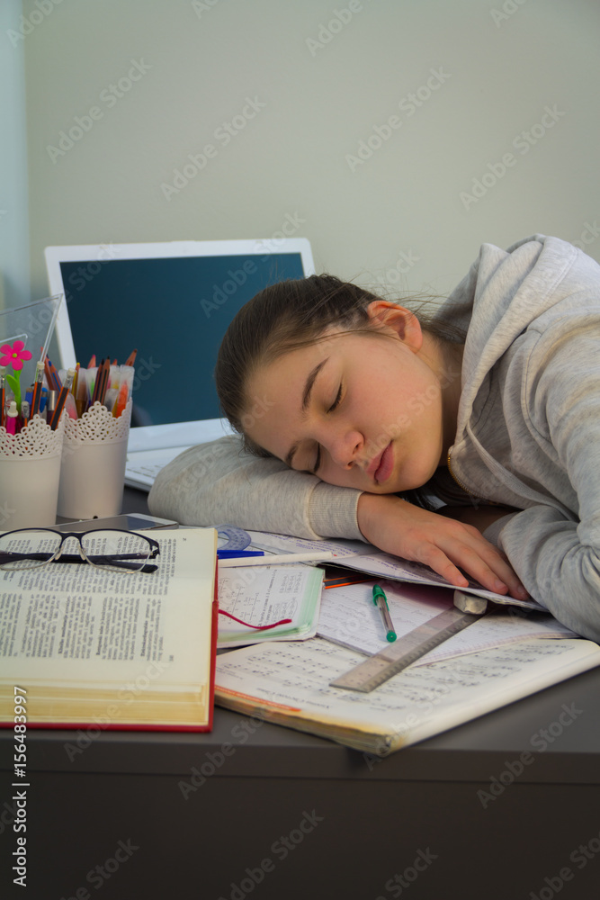 Teenage girl had fallen asleep at his desk tired of learning Teenage girl had fallen asleep at his desk tired of learning