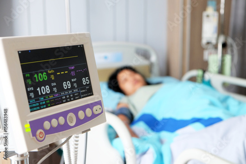 Vital sign monitor with background of blurry Asian woman patient