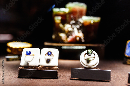 jewellery rings witht blue sapphir and green alexandrit on the background of the same minerals photo