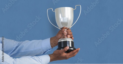 Hands holding trophy against blue background