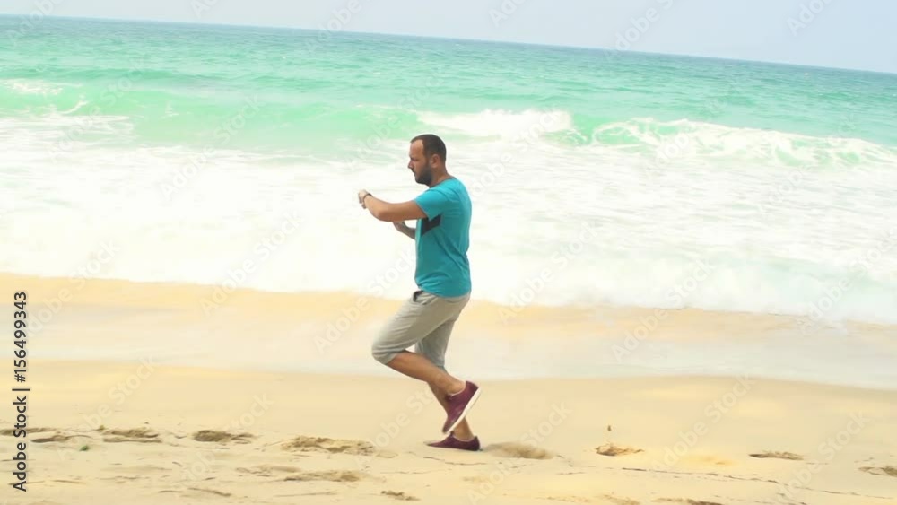 Man jogging and checking pulse on smartwatch on beach
Man jogging and checking pulse on smartwatch on beach