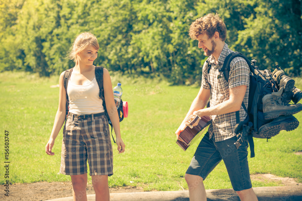 Obraz premium Hiking young couple with guitar backpack outdoor