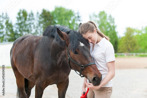 Chestnut horse together with her favorite owner young teenage girl