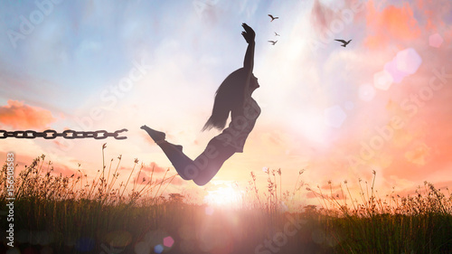 Foto World environment day concept: Silhouette of a girl jumping and broken chains at