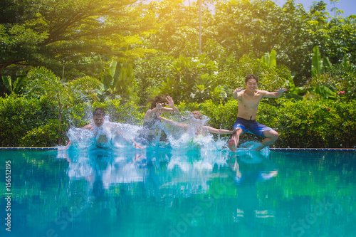Group Of Friends On Vacation Jumping Into Outdoor Pool © Panumas
