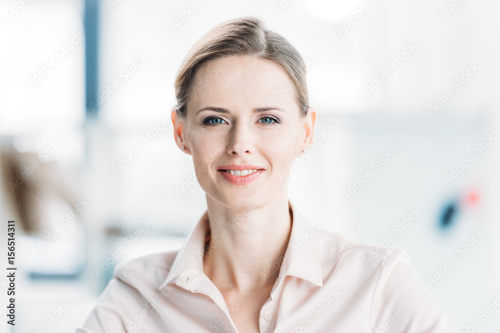 close up portrait of young smiling caucasian businesswoman at office