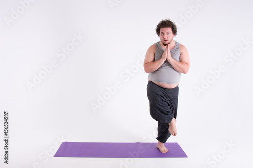 Funny fat man and yoga. Sport, diet and a healthy lifestyle. 