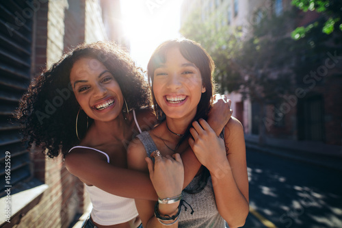 Two young women having fun on city street photo