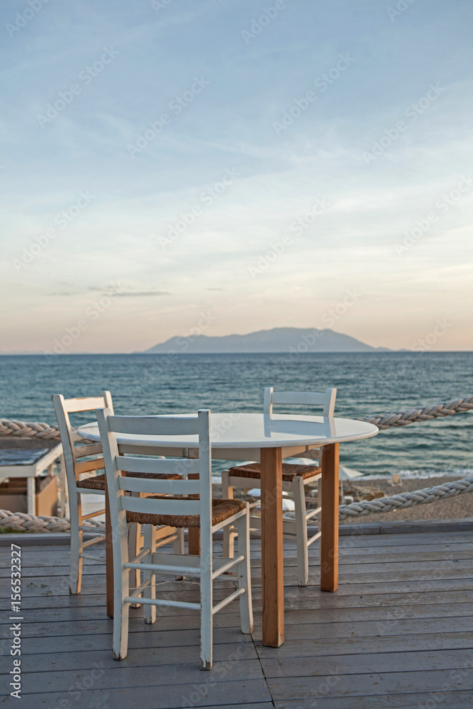 Restaurant table and chairs with a relaxing view of Samothraki island, Greece. Restaurant table and chairs with a relaxing view of Samothraki island, Greece.