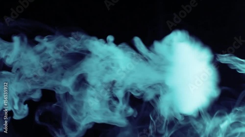 Vapor like smoke at blue polar shade on a dark black background. Vape smoke rings in motion at vape clouds.