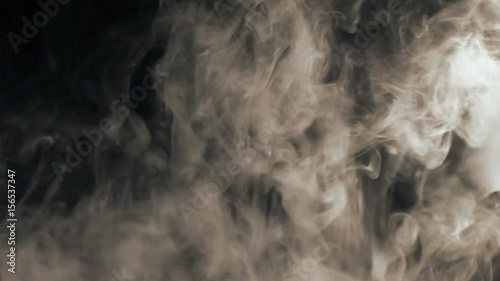 Vapor like smoke at sepia on a dark black background. Vape smoke rings in motion at vape clouds.