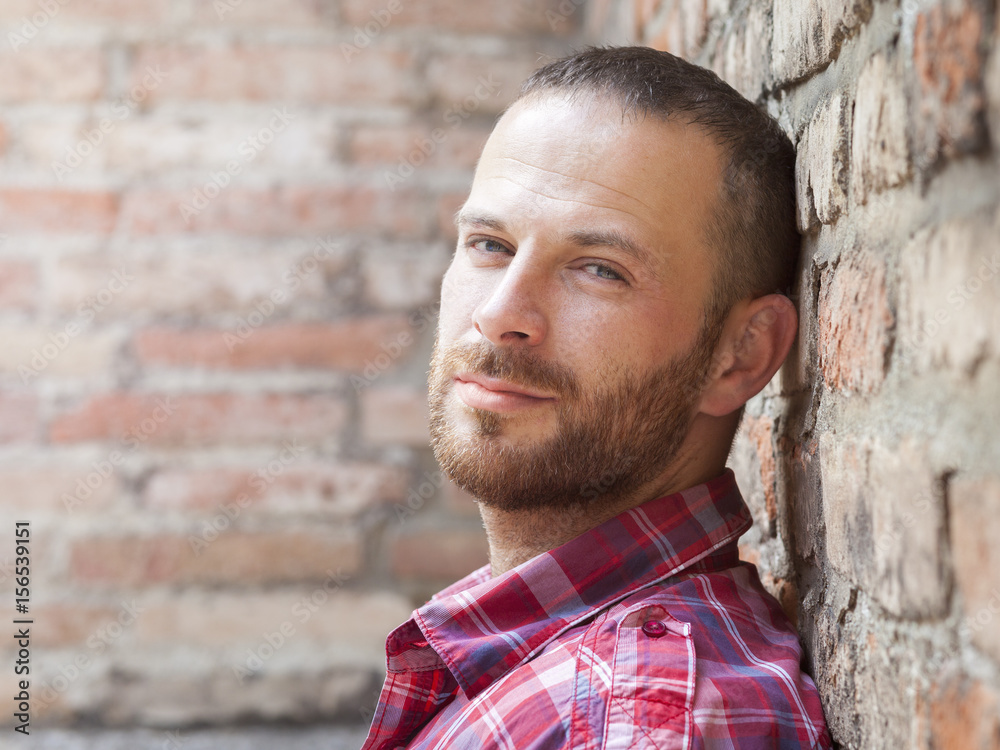 Obraz premium man portrait at the brick wall
