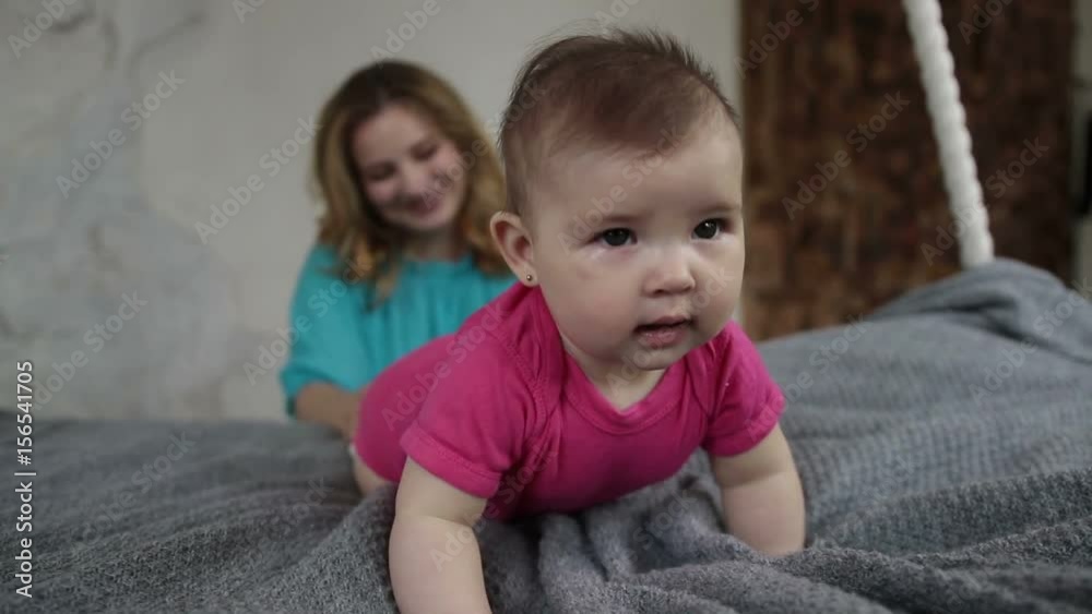 Adorable baby girl learning to crawl on bed Adorable baby girl learning to crawl on bed