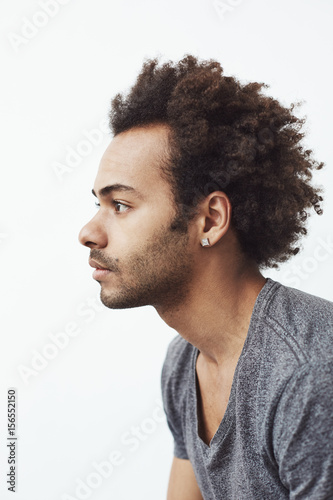 Portrait of young african man in profile over white background.