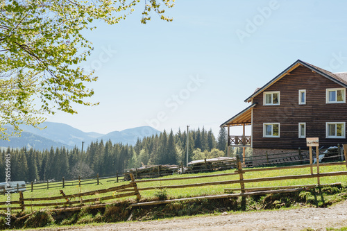 Wooden country house with fence in mountains. Beautiful landscape. Carpathians.