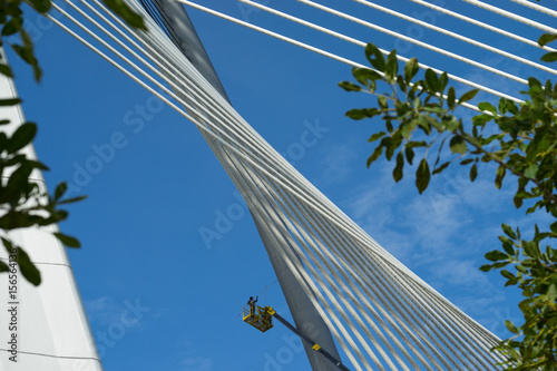 Men perform a maintenance work at Seri Wawasan bridge - a cable-stayed bridge with 165m main span and supported by 30 pairs of forward stay cables photo