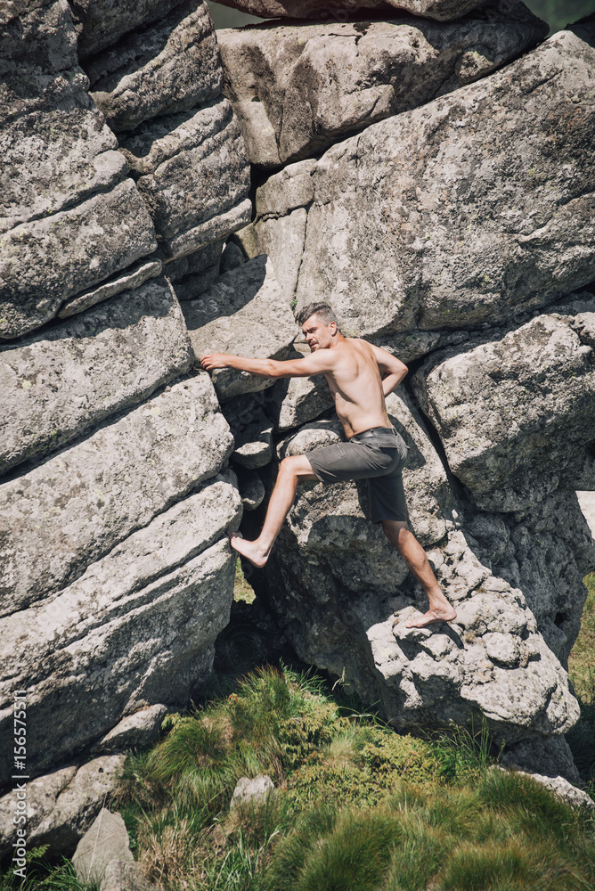 Athletic man climbing on the mountain rock