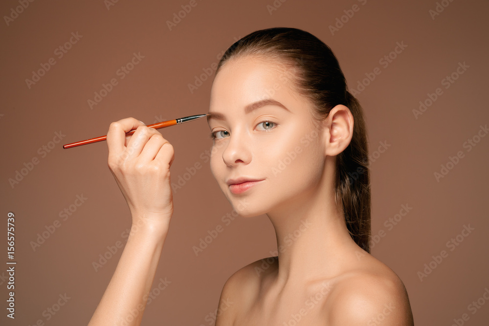 Beautiful female eyes with make-up and brush Beautiful female eyes with make-up and brush