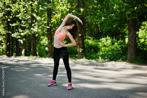 Fitness sport girl in sportswear doing stretching exercise in road at park, outdoor sports, urban style.