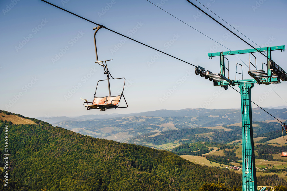 Ski lift with blue sky and mountains on the background