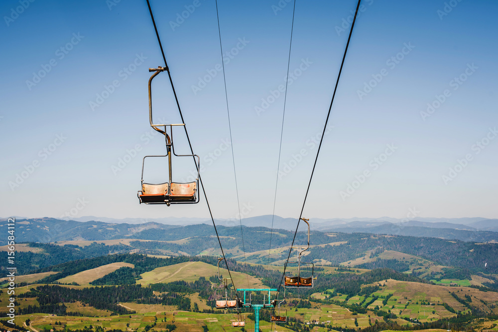 Ski lift with blue sky and mountains on the background