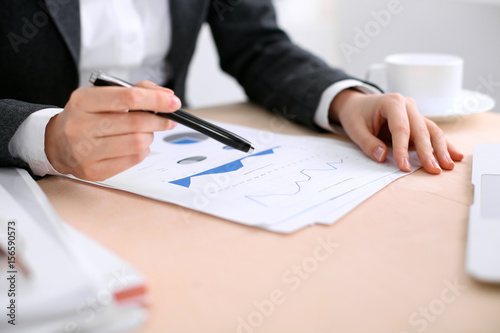 Business woman sitting at the table and examines the financial results