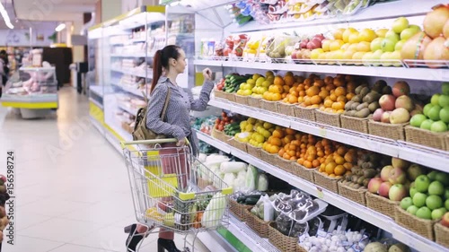 Young woman chooses fruits in the supermarket