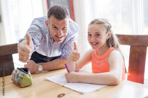 Male Home Tutor Helping Teenage Girl With Studies photo