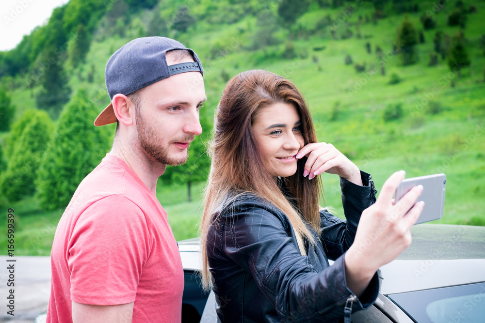 Happy young couple, friends making selfie while sitting in car. Summer time. Caucasian people. Concept of transportation. 
