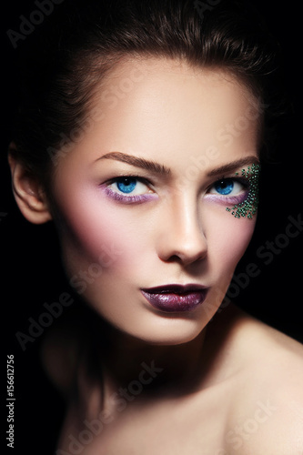 Portrait of young beautiful woman with stylish glitter make-up, selective focus