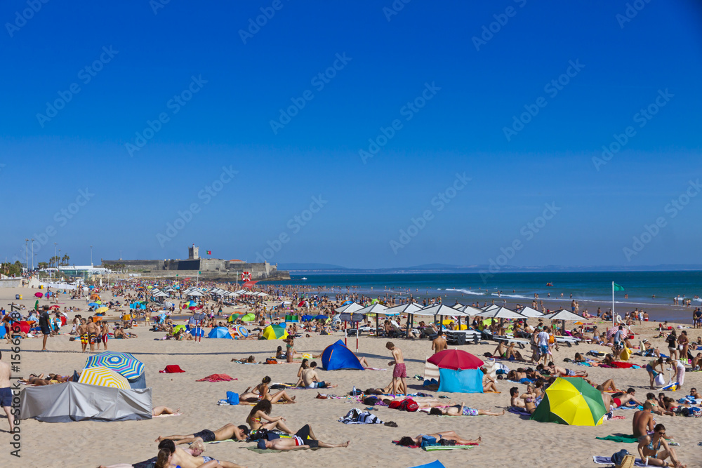 Crowded Atlantic Ocean beach in Lisbon, Portugal