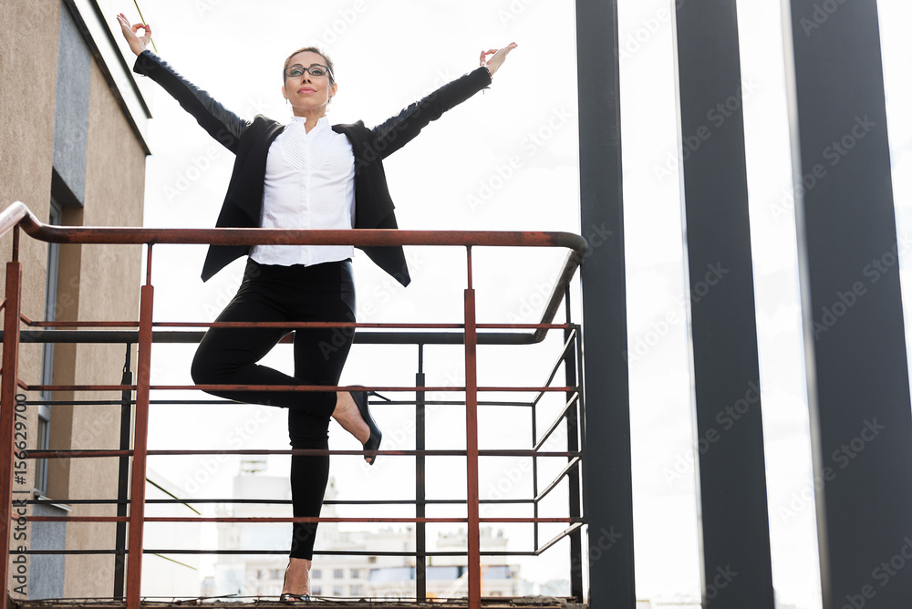 Fototapeta premium Happy woman meditating on balcony