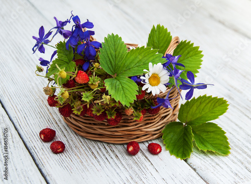 Basket with wild strawberries and wildflowers