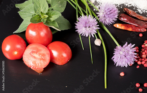 Tomate und Schnittlauch auf schwarzem Hintergrund