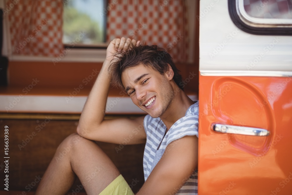 Smiling young man looking away while sitting in van Smiling young man looking away while sitting in van