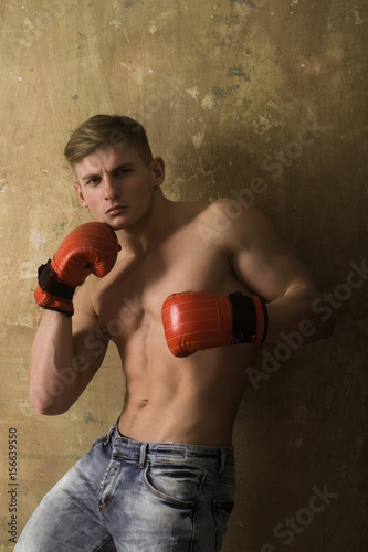 man boxer with red boxing gloves in muscular arms © Volodymyr