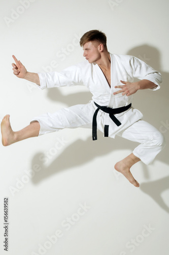Handsome karate master jumping in fighting stance