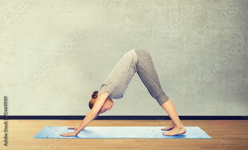 woman making yoga dog pose on mat