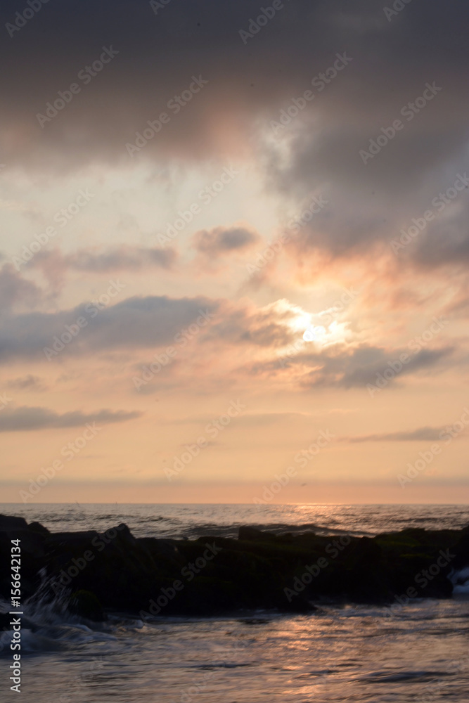 Heavenly Summer Seashore Sunrise Over Rock Jetty on the Beach