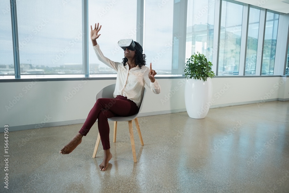 Female executive using virtual reality headset in office Female executive using virtual reality headset in office