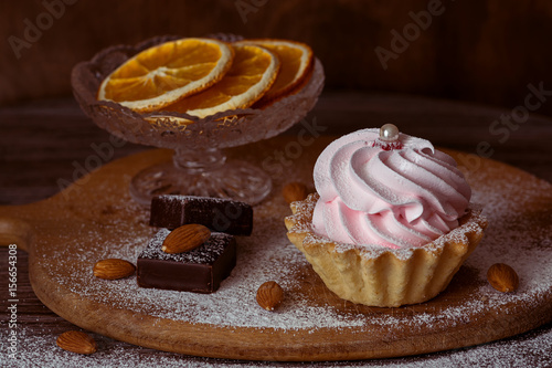 The cream puff on the table . A table decorated with nuts ,chocolate and Suginami oranges. photo