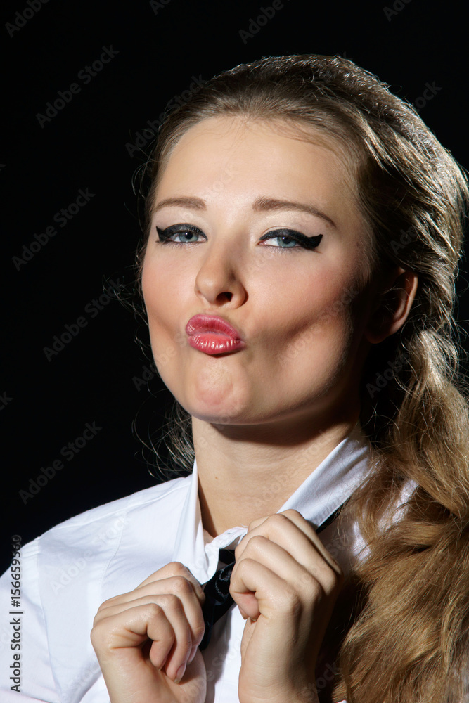 Obraz premium portrait of young beautiful caucasian female with pink lips and blue eyes kissing you or camera isolated on black background