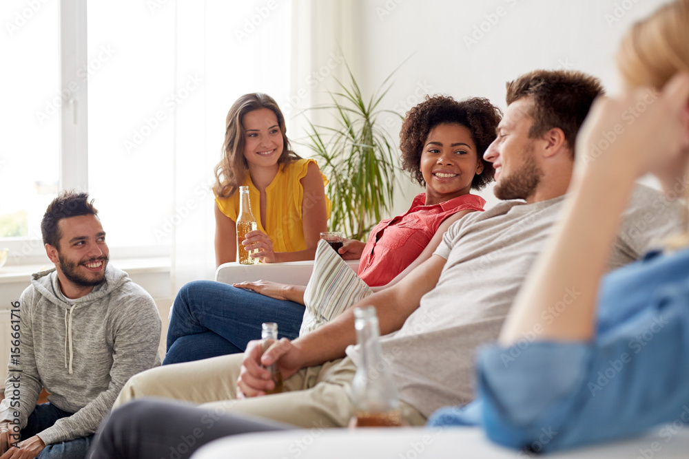 group of happy friends with drinks talking at home group of happy friends with drinks talking at home