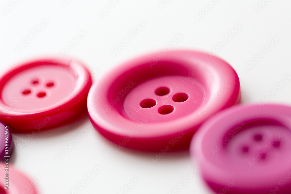 red and pink sewing buttons on white background red and pink sewing buttons on white background