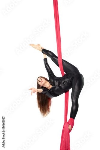 Woman girl gymnast acrobat practicing aerial air yoga acrobatics in studio isolated